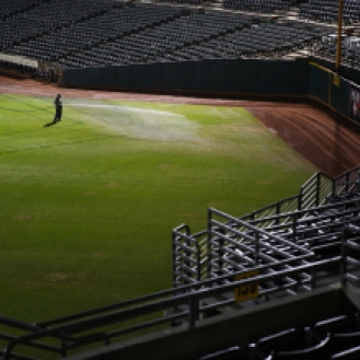A member of the Oakland Coliseum grounds crew waters the grass in left field on Monday, August 31, 2015, after a baseball game between the Oakland Athletics and the Los Angeles Angels of Anaheim. The stadium’s turf endured a Raiders football game less than 24 hours prior to the start of the Athletics game.